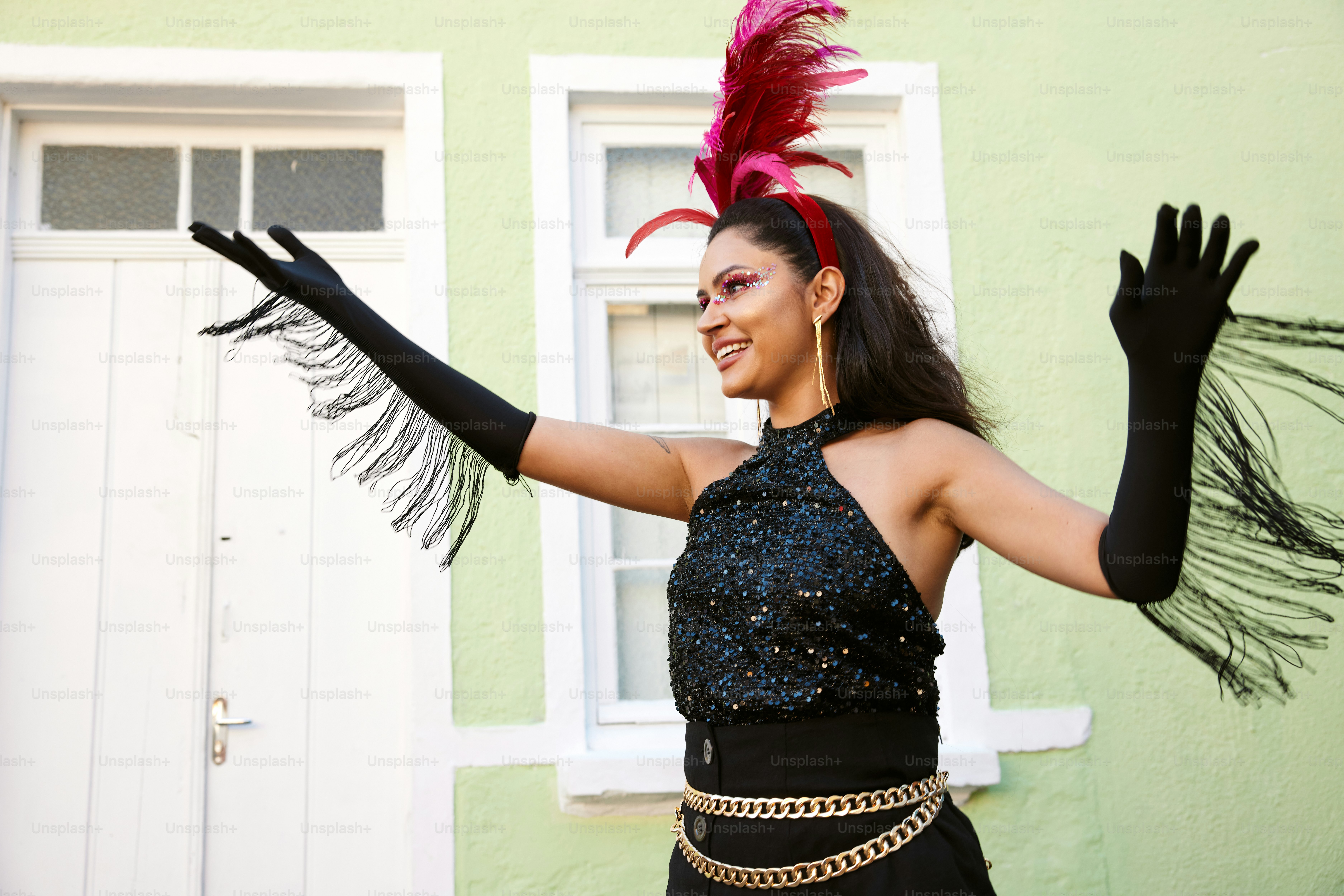 a woman wearing a black dress and a pink feathered hat