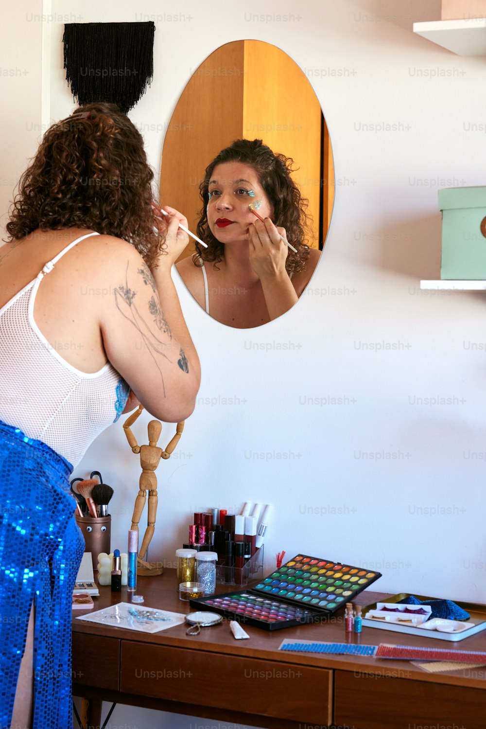 a woman in a white tank top brushing her teeth