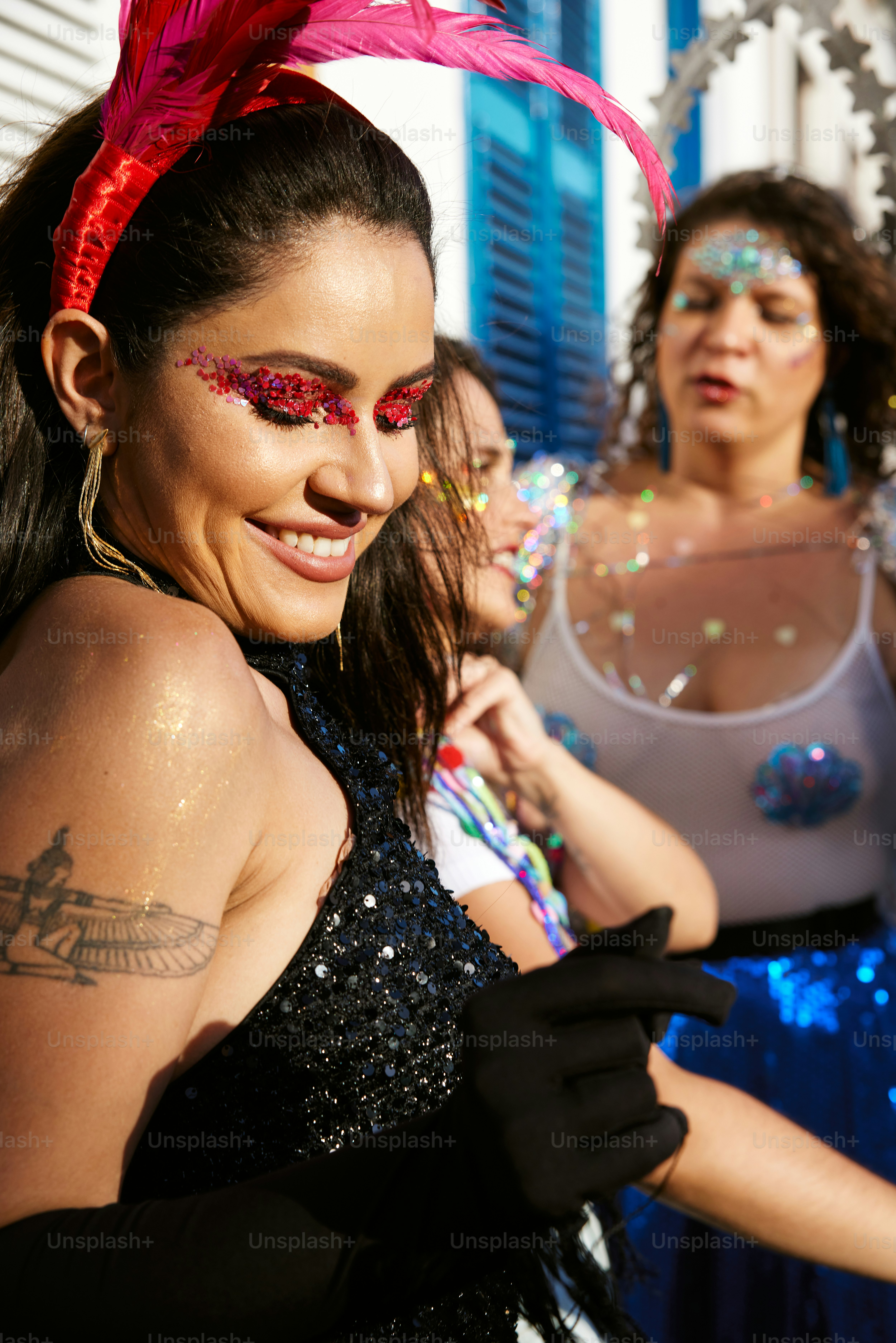 a woman in a black dress with a red feather on her head