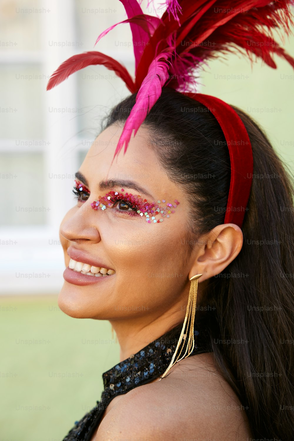 a woman wearing a red feather head piece