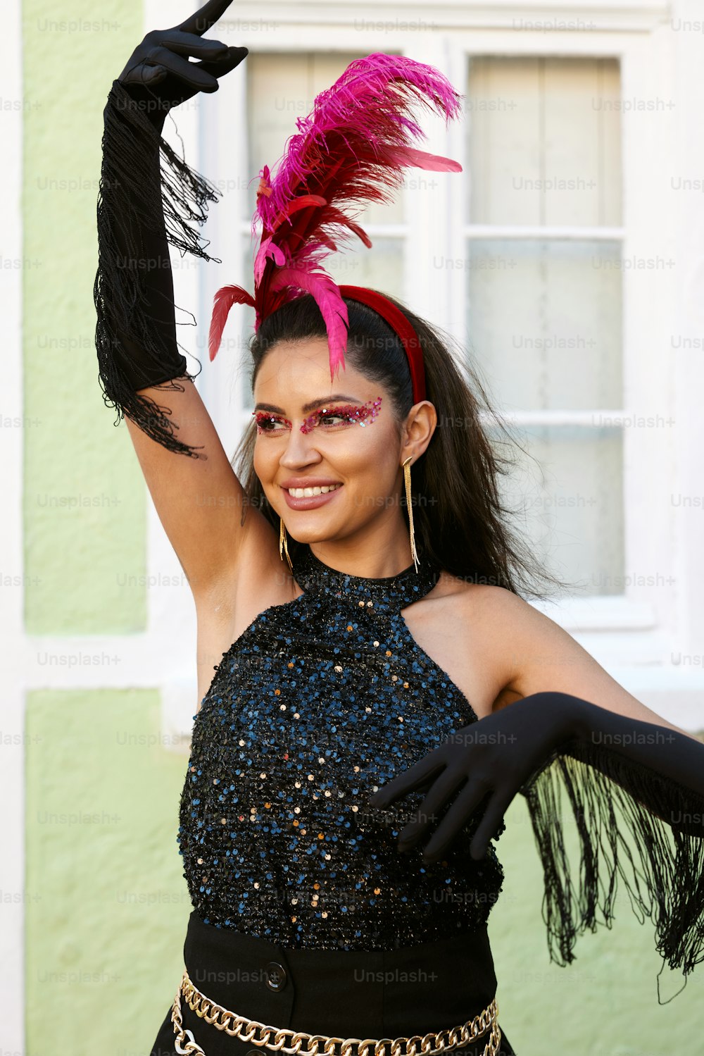 a woman wearing a black dress and a pink feathered hat