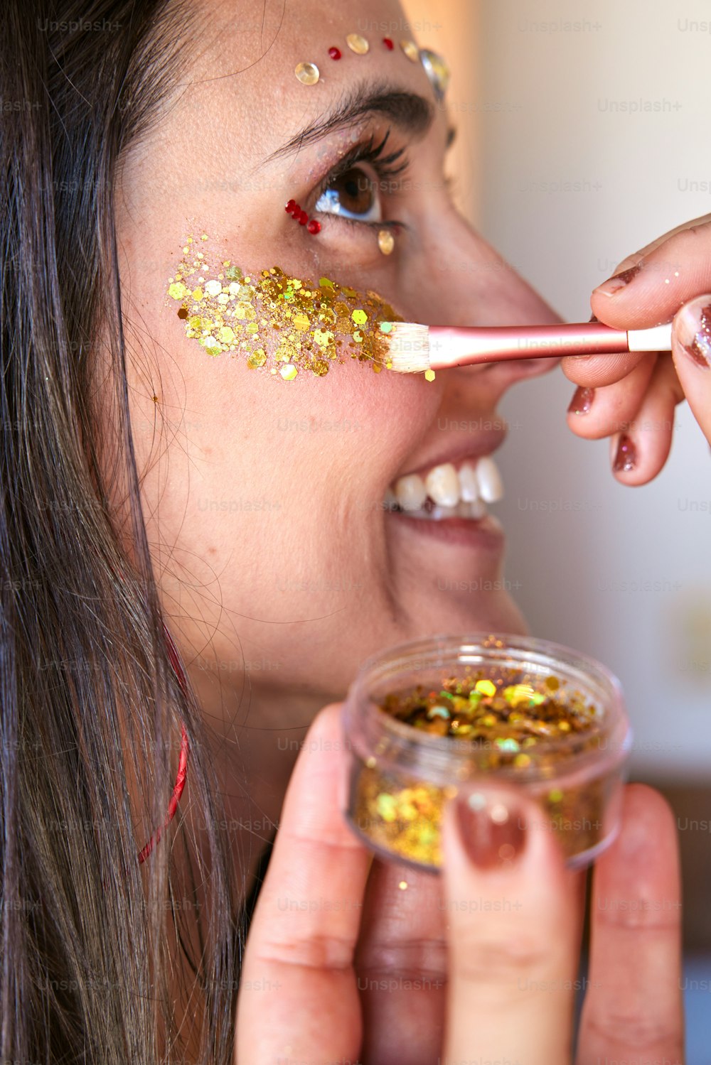 Une femme met des flocons d’or sur son visage