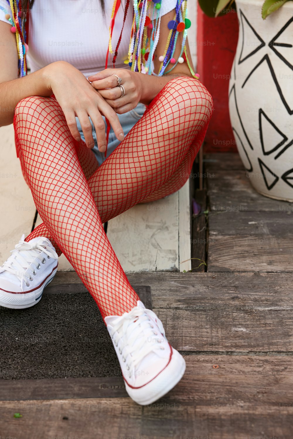 a woman sitting on a step wearing fishnet stockings