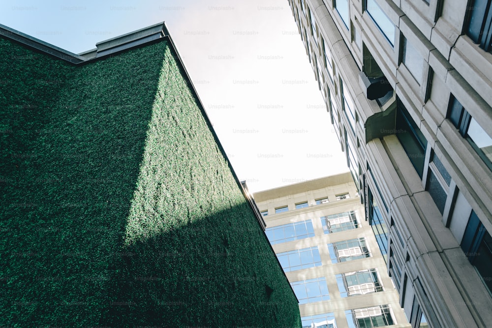 a tall building with a green roof next to a tall building