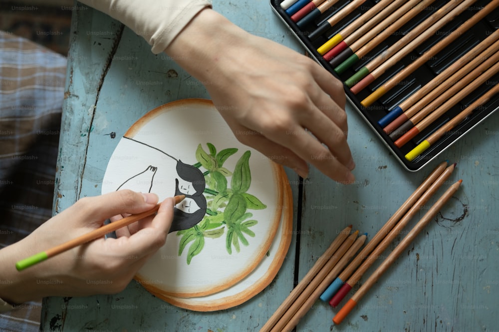 a person is painting a picture on a plate