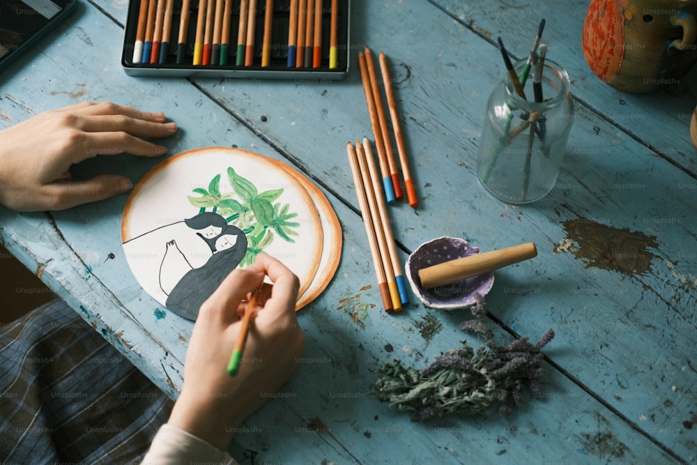 a person is painting a picture on a plate