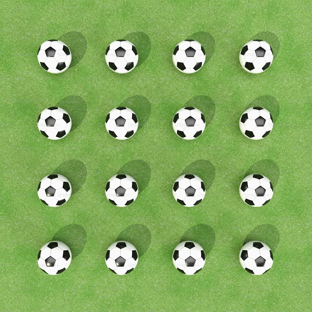Un grupo de balones de fútbol sentados encima de un campo verde