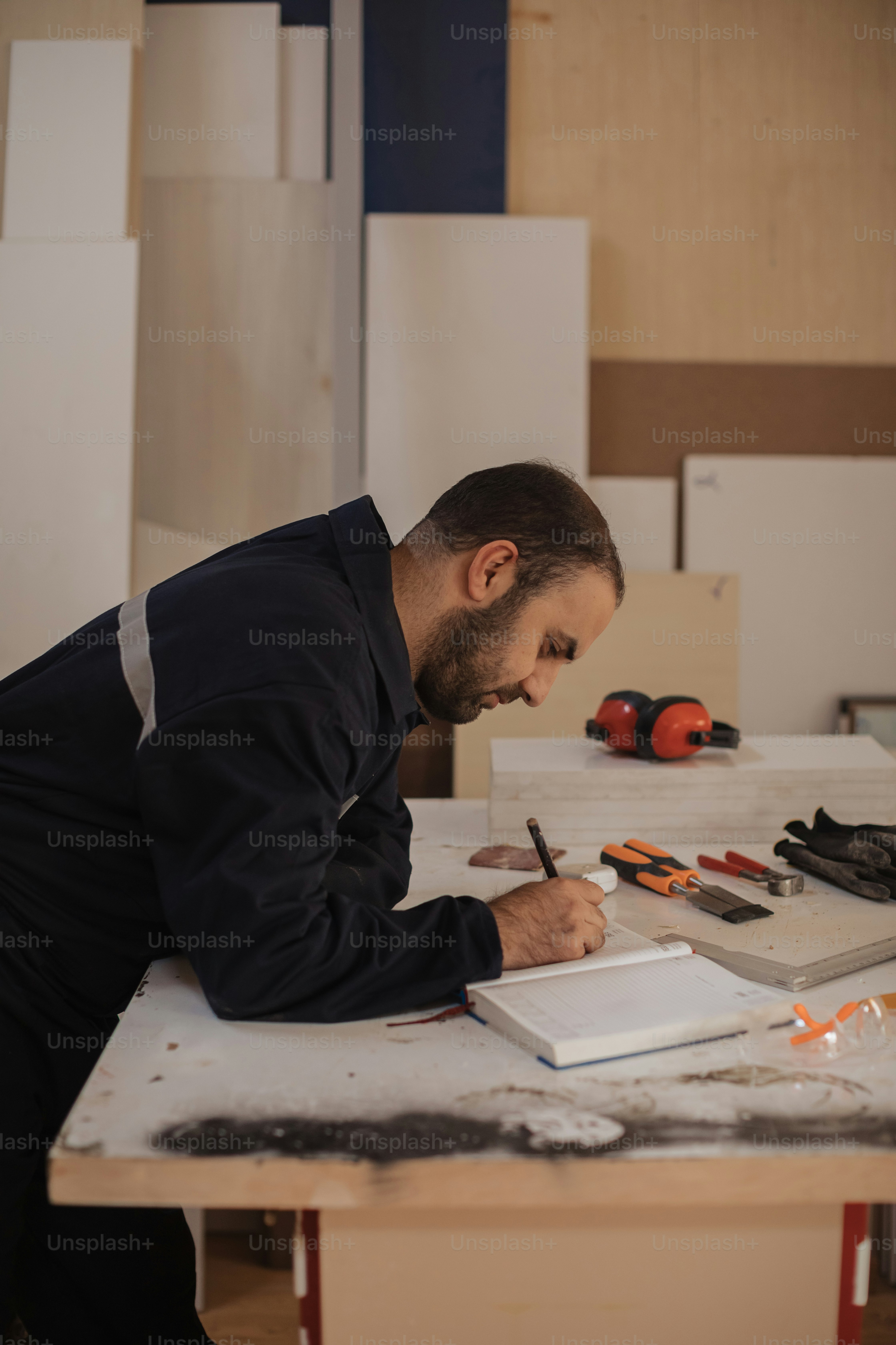 a man sitting at a table writing on a piece of paper