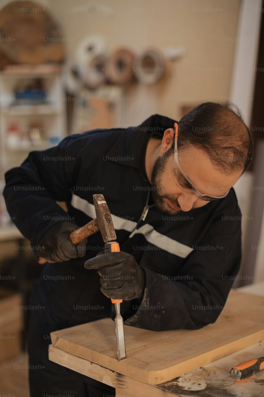 Un uomo che lavora con un martello su un pezzo di legno