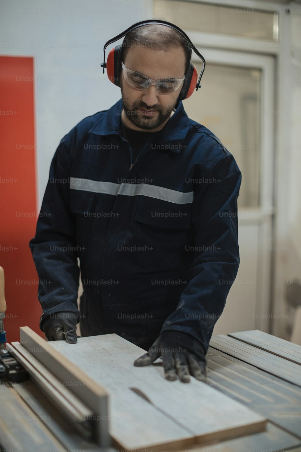 a man with headphones on working on a piece of wood