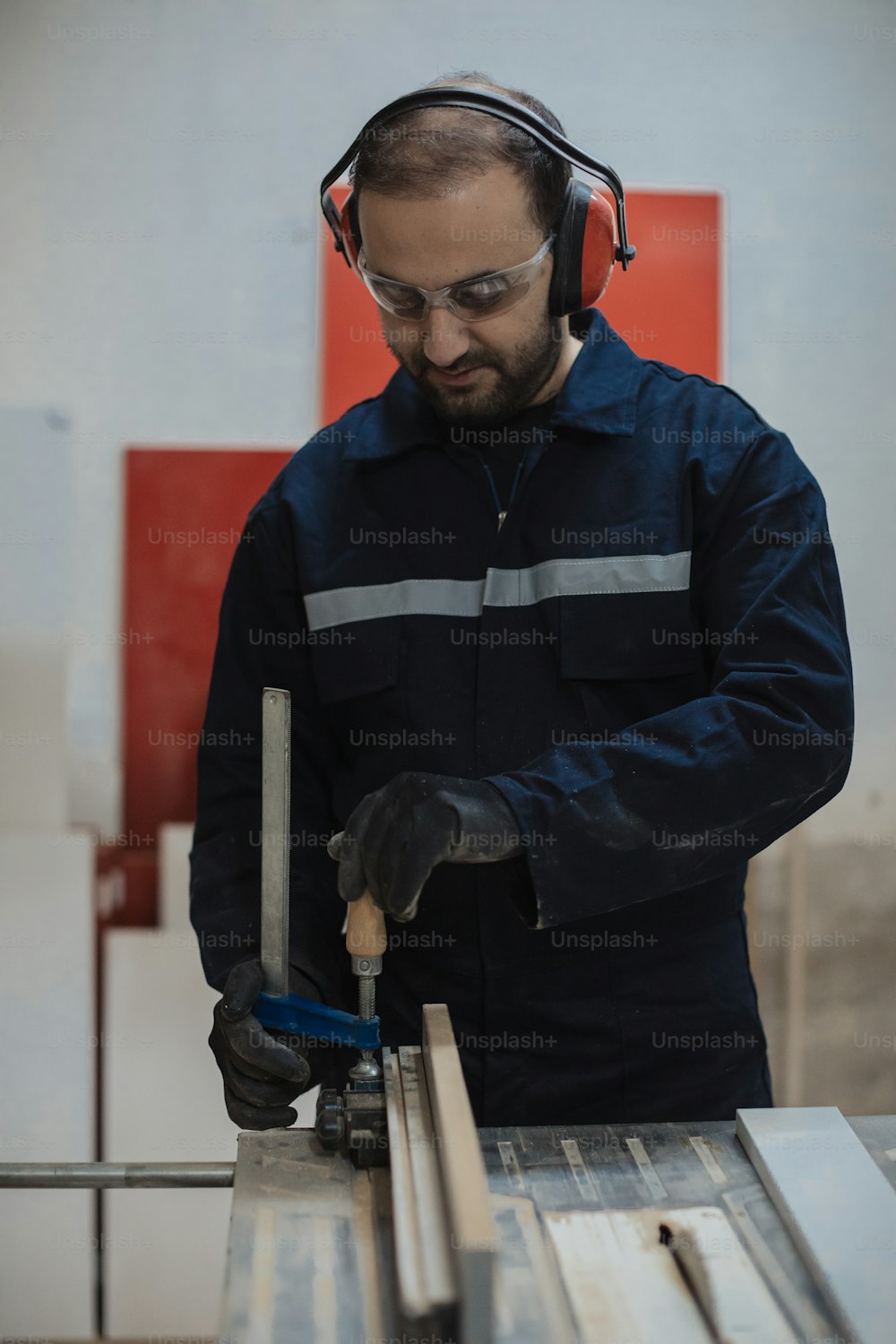 a man with headphones on working on a piece of wood