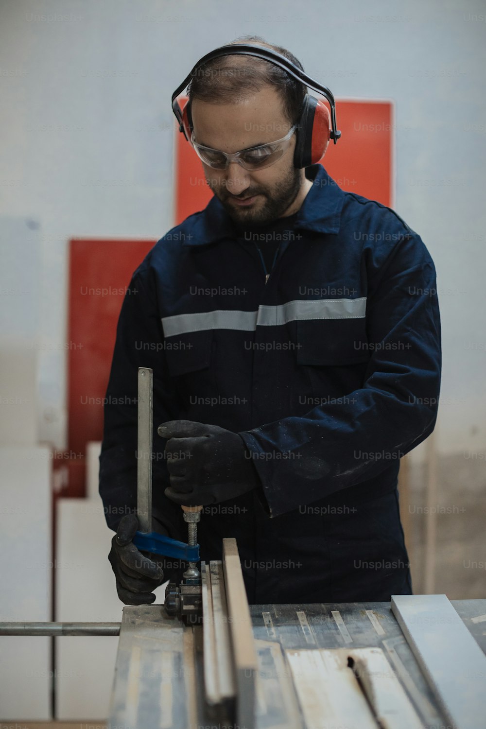 a man wearing headphones working on a piece of wood