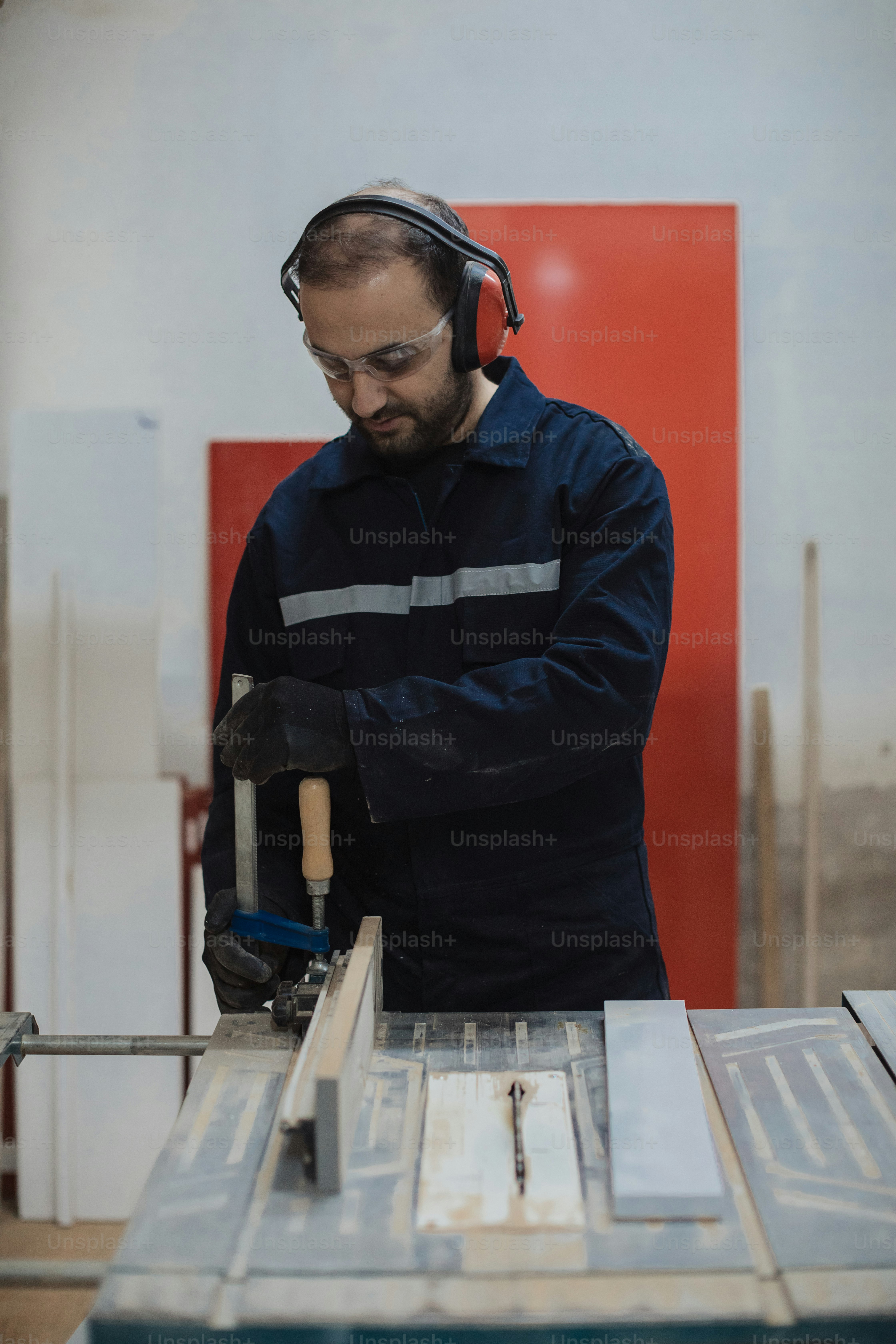 a man wearing headphones working on a piece of wood