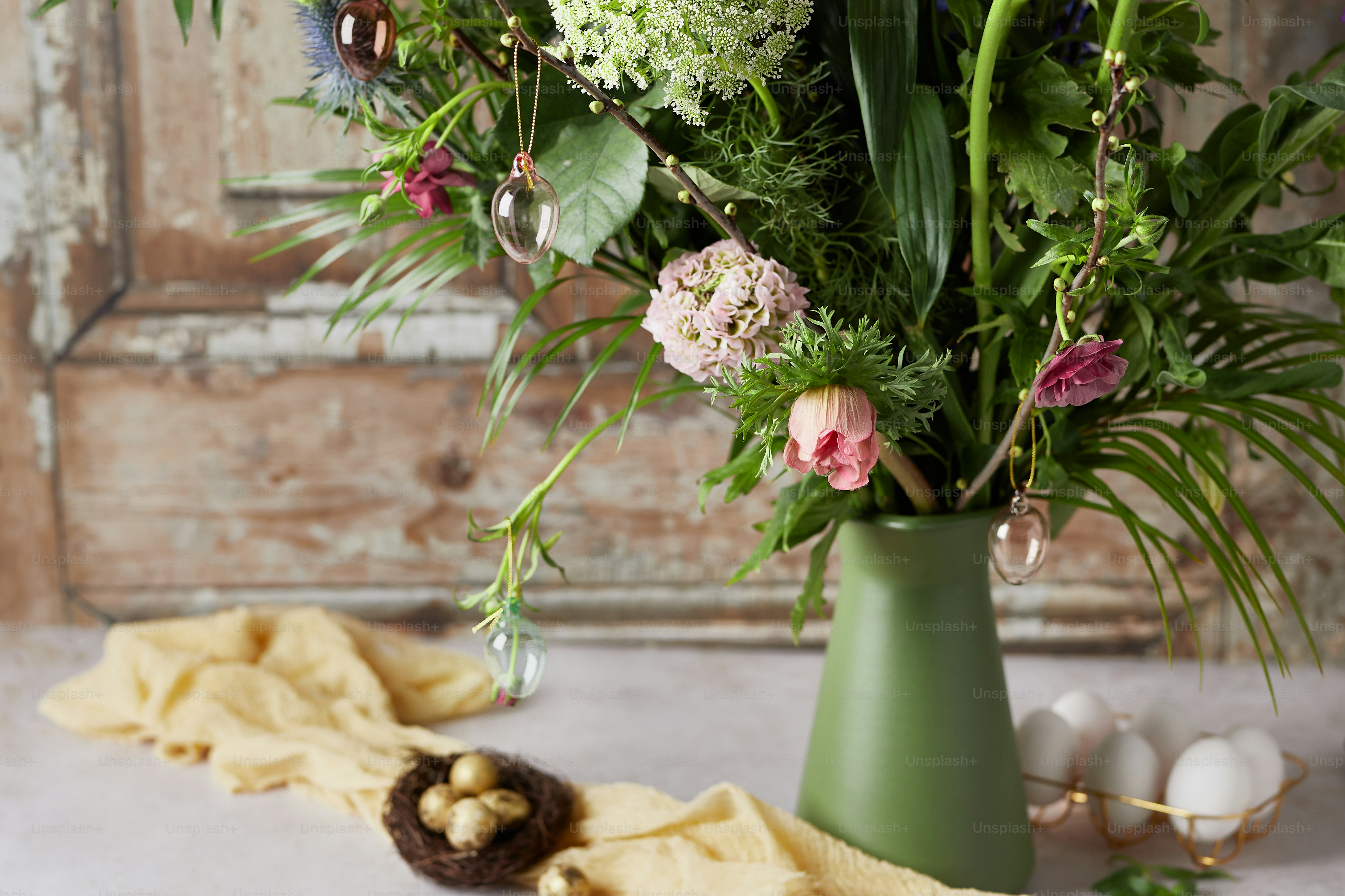 eine grüne Vase gefüllt mit vielen Blumen
