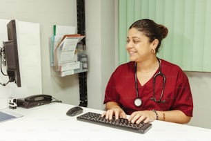 a woman with a stethoscope is typing on a keyboard