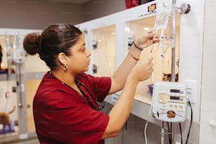 Una mujer con una camisa roja está trabajando en una máquina