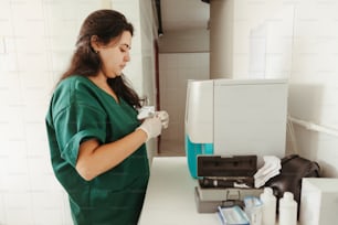a woman in green scrubs her hands in front of a machine