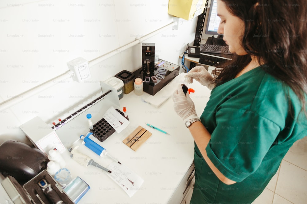 a woman in green scrubs her hands near a counter