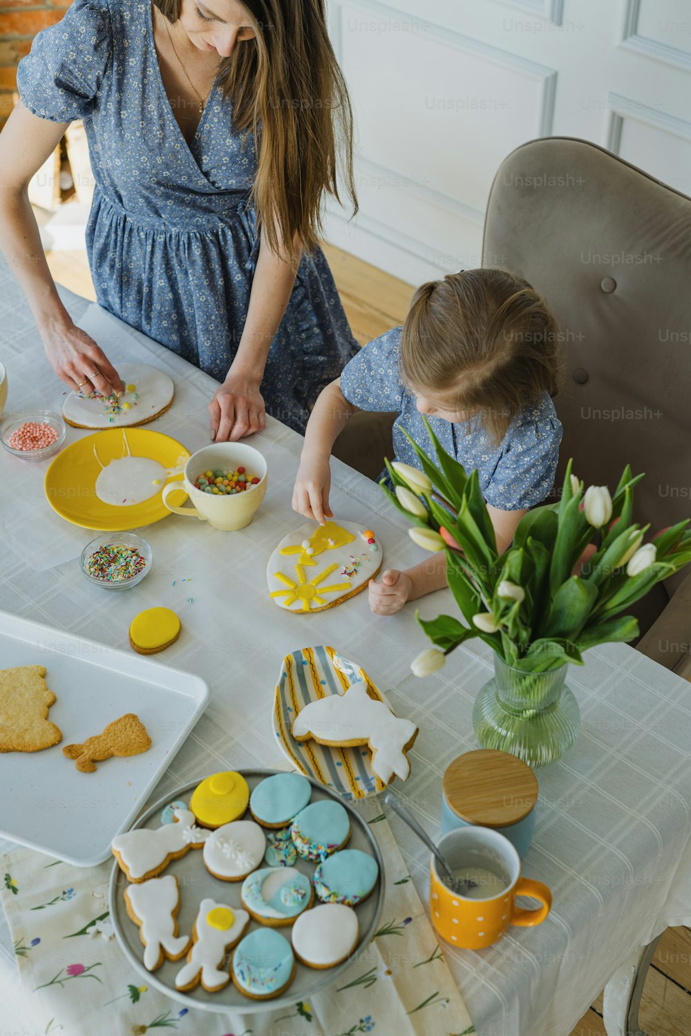 a woman and a child are making cookies