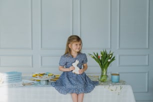 Une petite fille assise sur une table avec un lapin