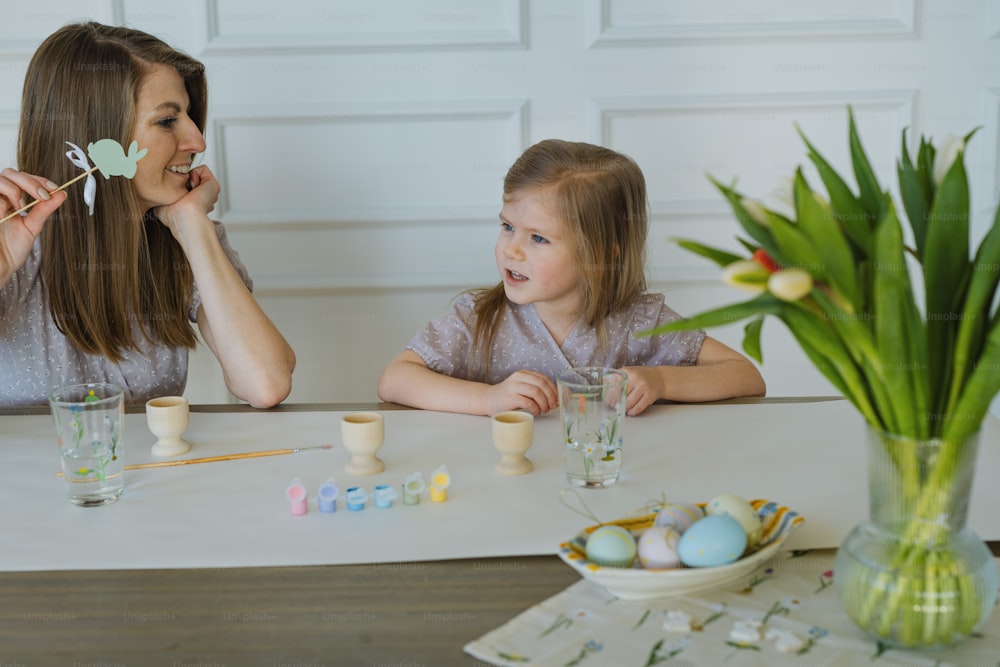 a woman and a little girl sitting at a table