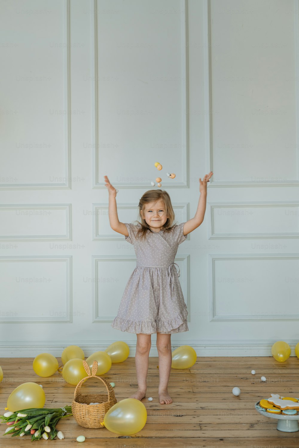 a little girl standing in front of a bunch of balloons