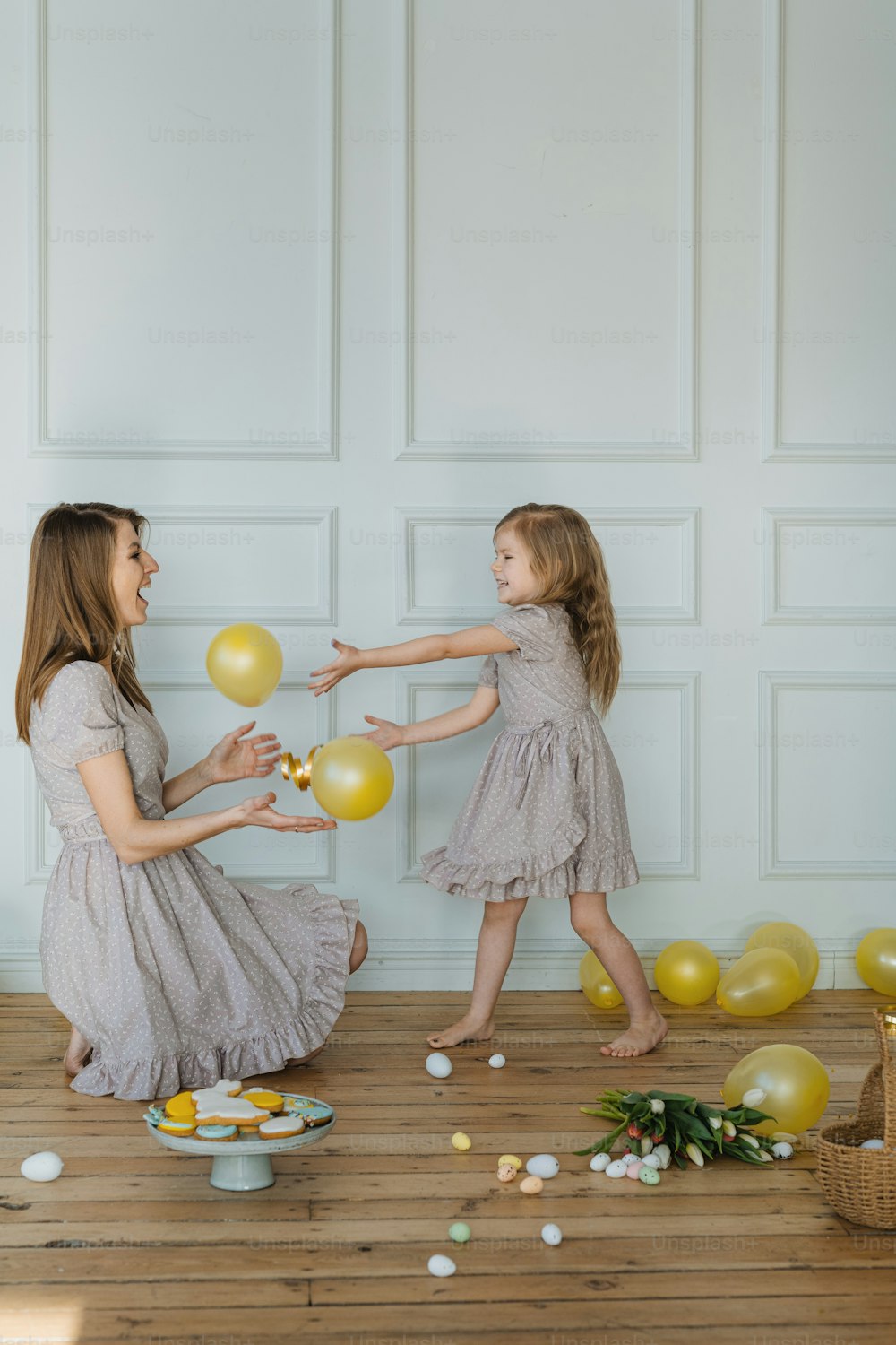 a mother and daughter playing with balloons and confetti