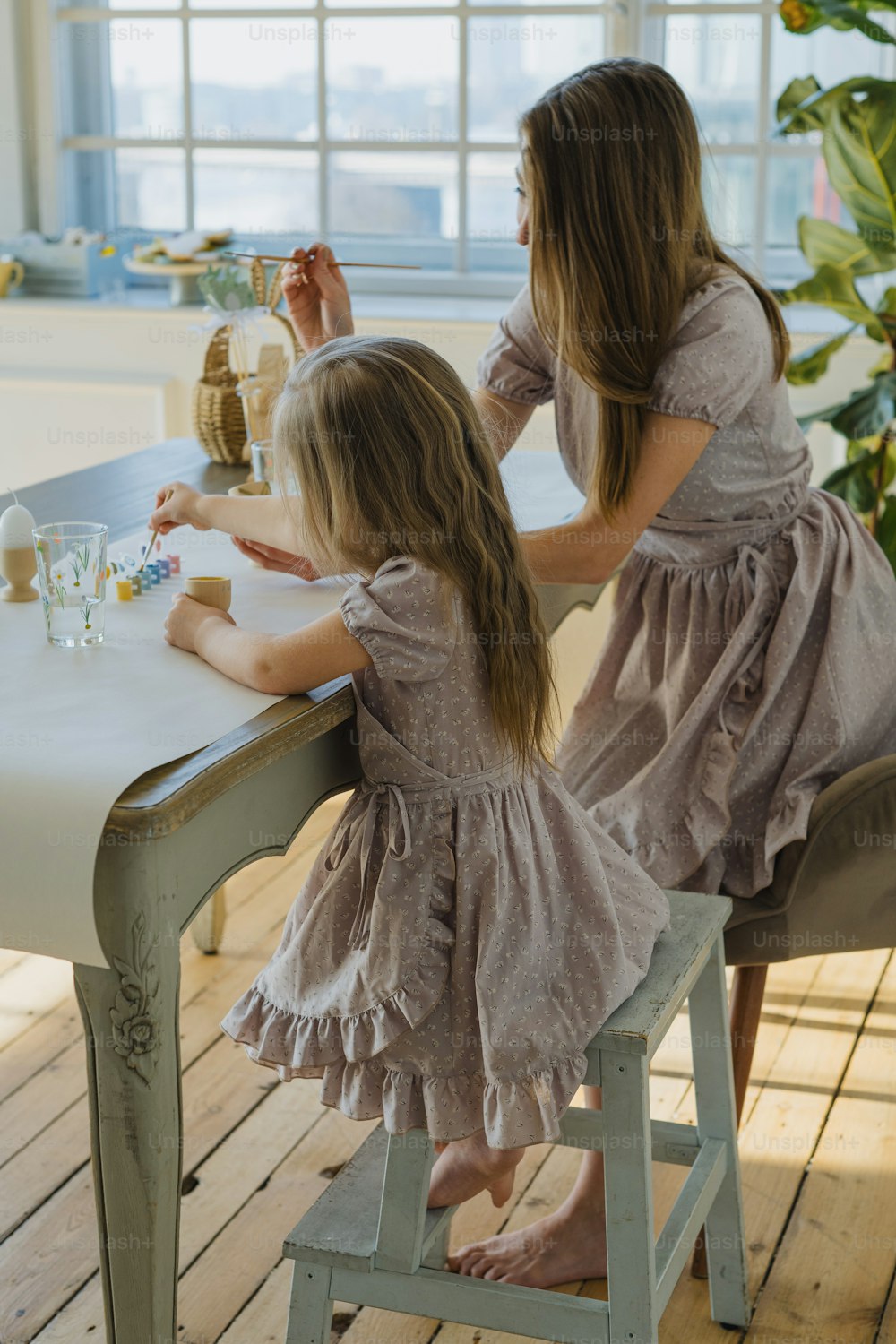 duas meninas sentadas em uma mesa brincando com brinquedos