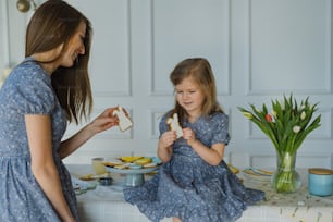 a woman and a little girl sitting at a table eating food