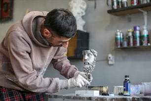 Un homme travaillant sur une statue dans un magasin