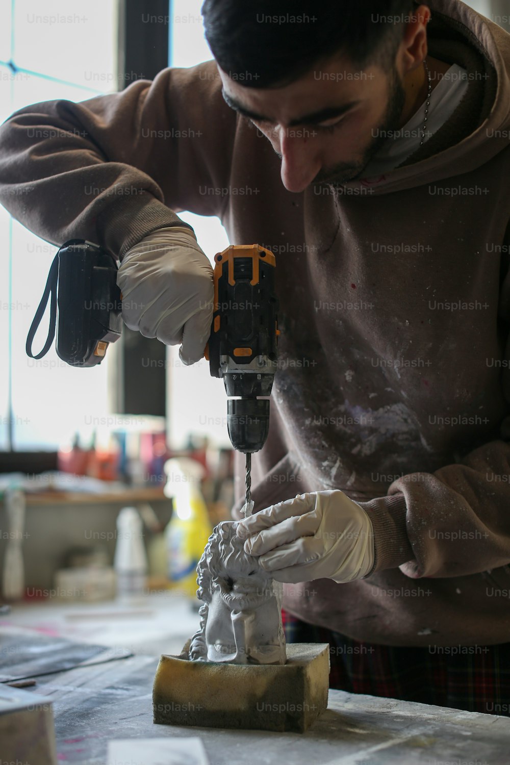 Un hombre trabajando con un perforador en un pedazo de madera