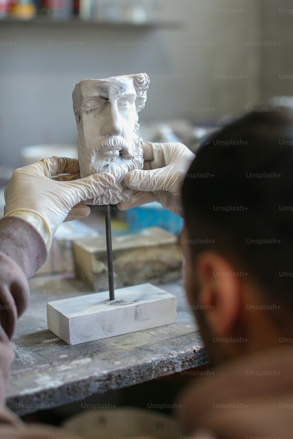 Un hombre está haciendo una estatua de un hombre con barba