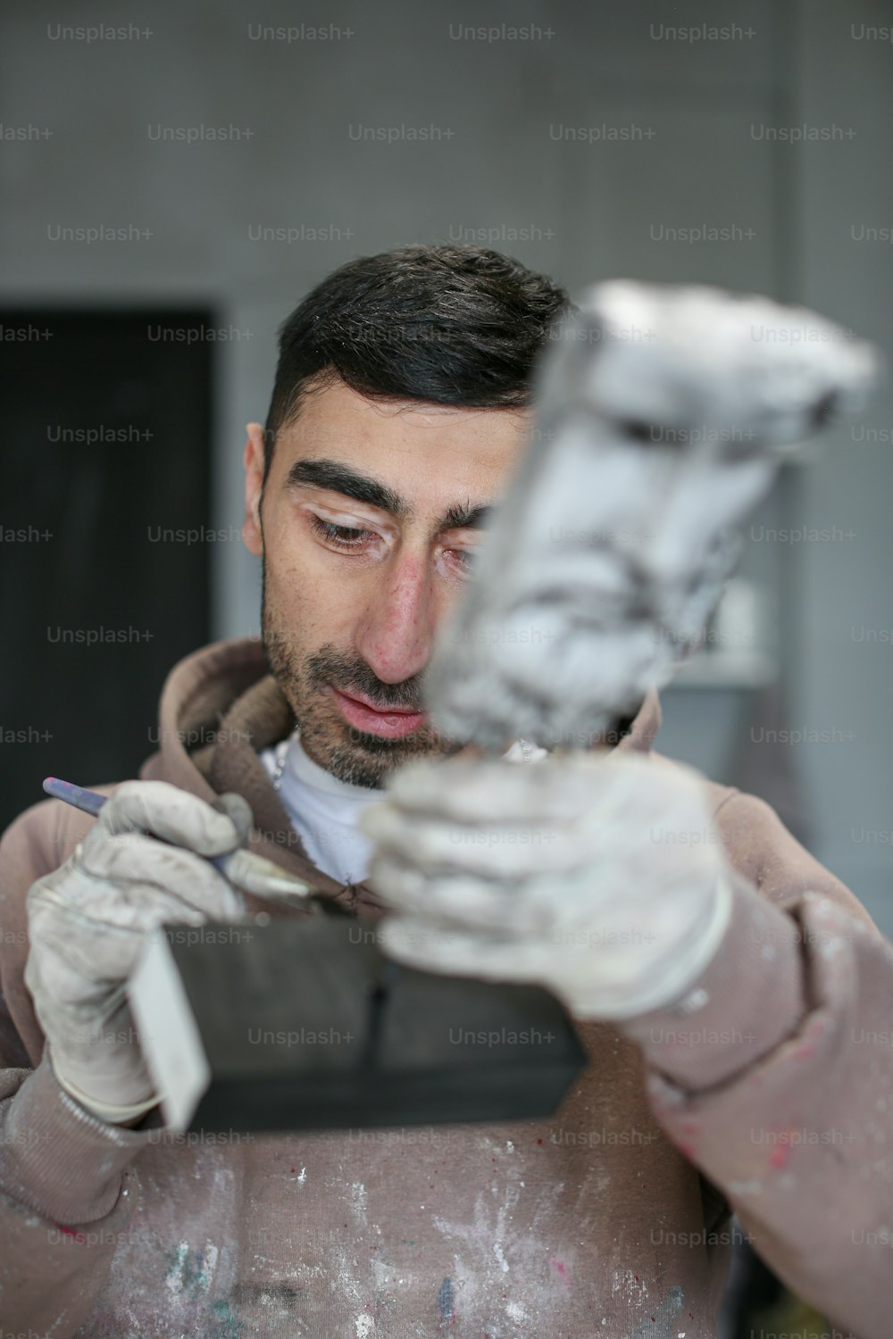 Un homme portant des gants blancs tenant un téléphone portable