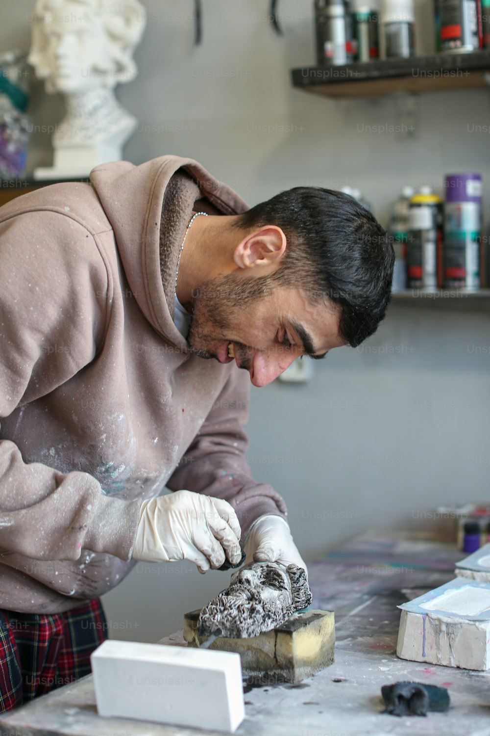 a man working on a sculpture in a studio