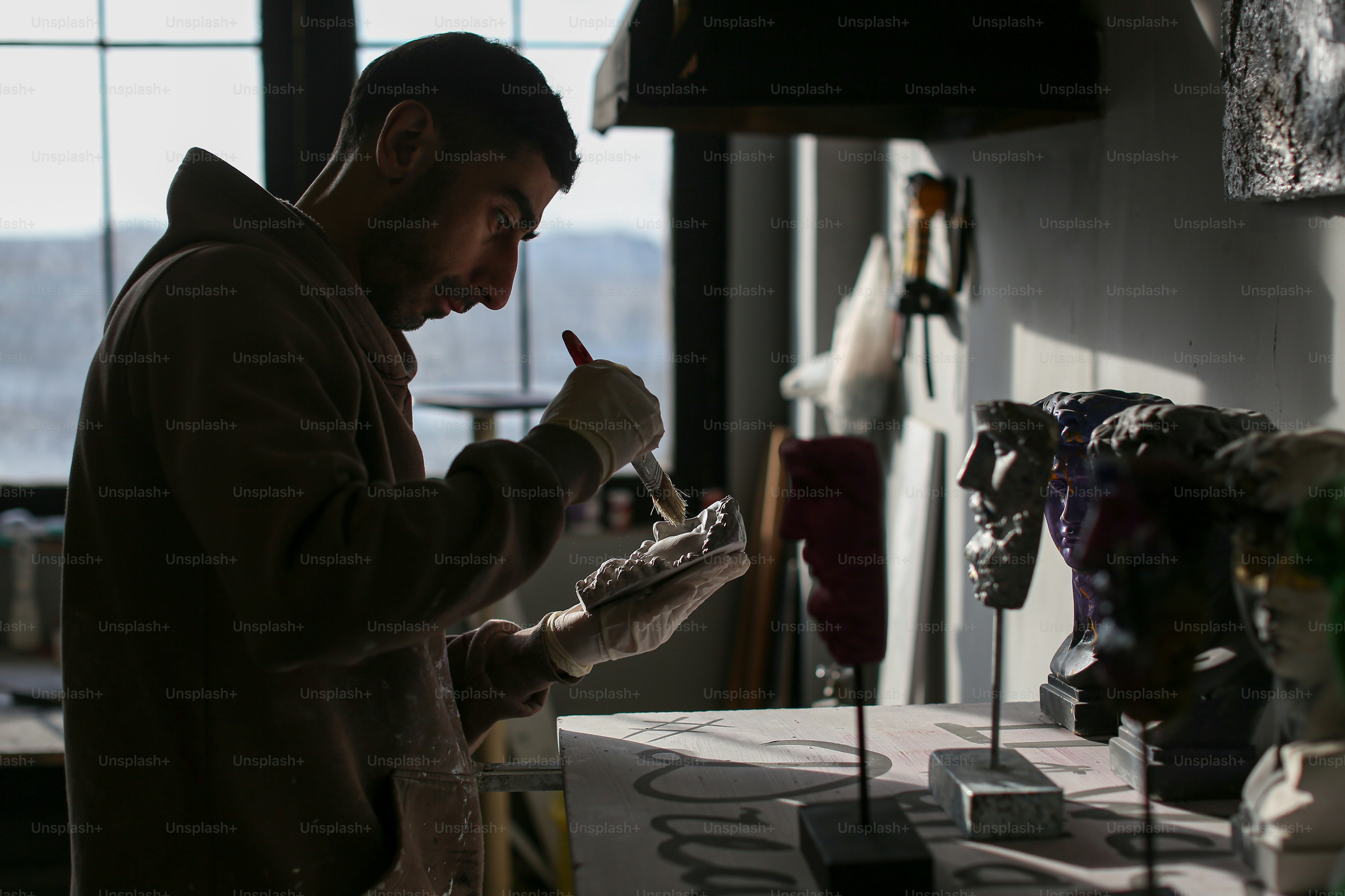 a man standing in front of a table holding a pencil