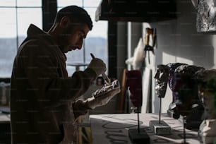 a man standing in front of a table holding a pencil