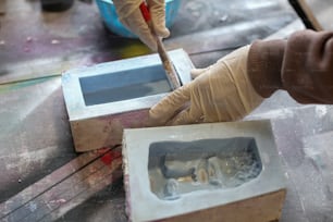 Una persona con guantes y guantes cortando un trozo de plástico