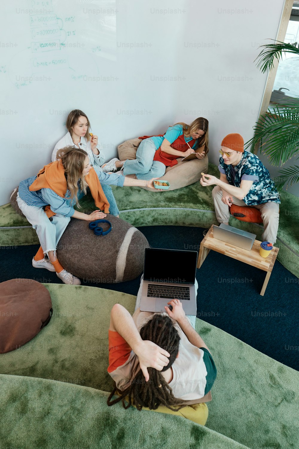 un gruppo di persone sedute su sacchi di fagioli in una stanza