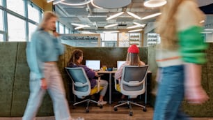 a group of people sitting at desks in an office