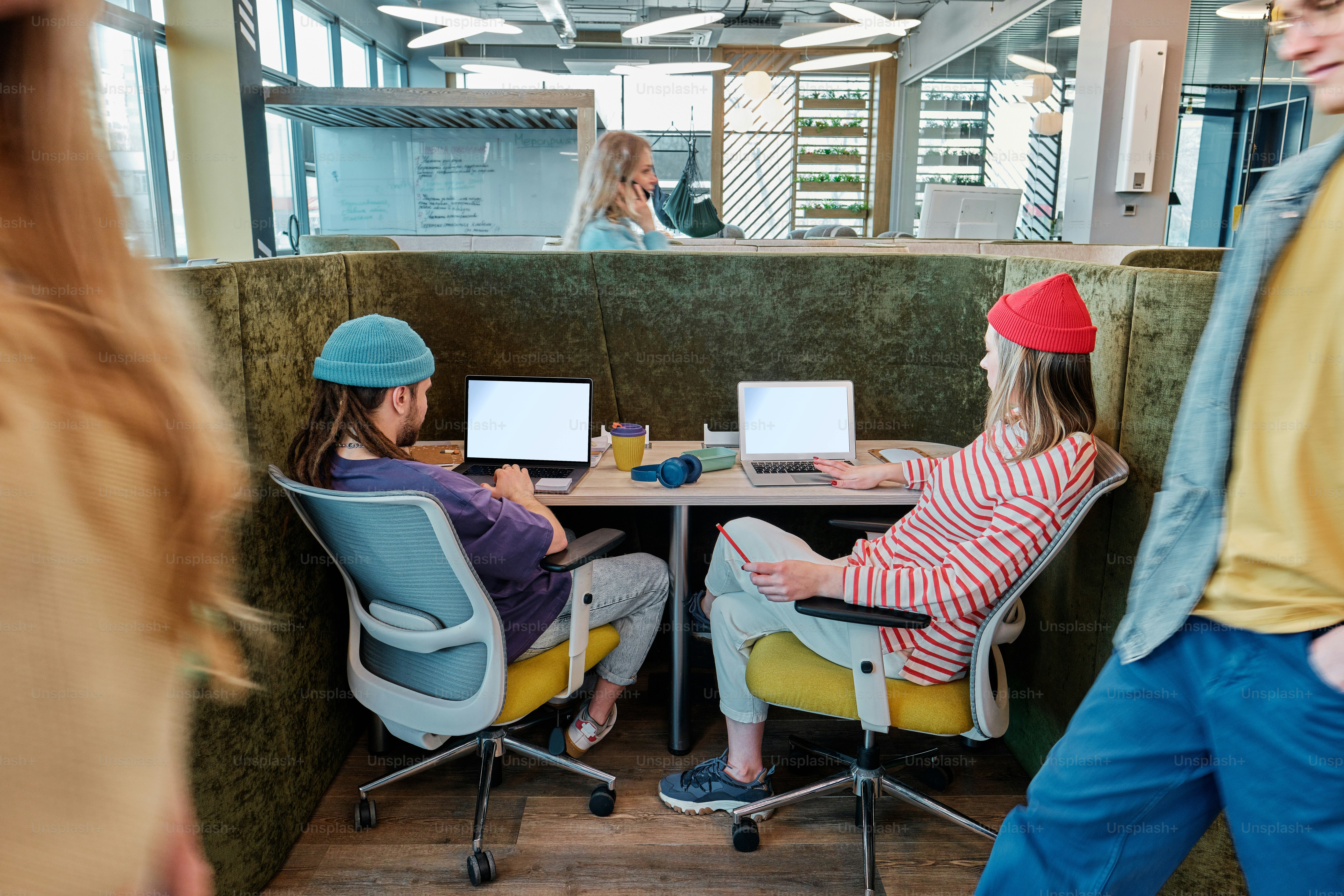 a couple of people sitting at a table with laptops