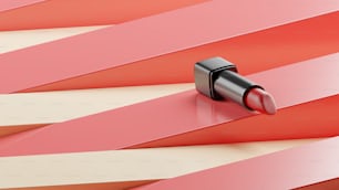 un rouge à lèvres sur une surface rayée rouge et blanche