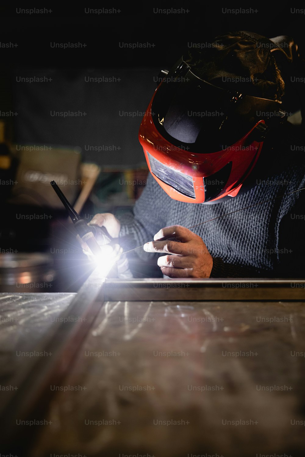 um homem em um capacete trabalhando em um pedaço de metal