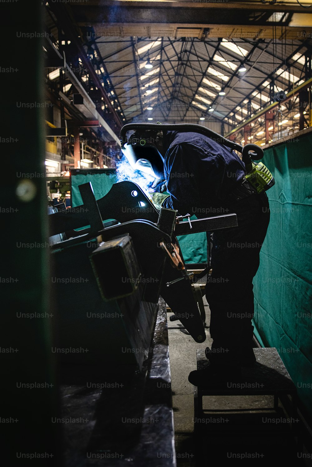 a man welding a piece of metal in a building