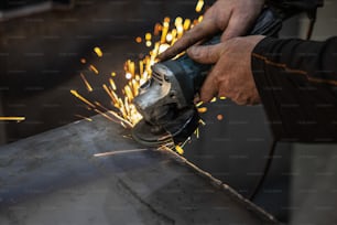 una persona che usa una smerigliatrice su un pezzo di metallo