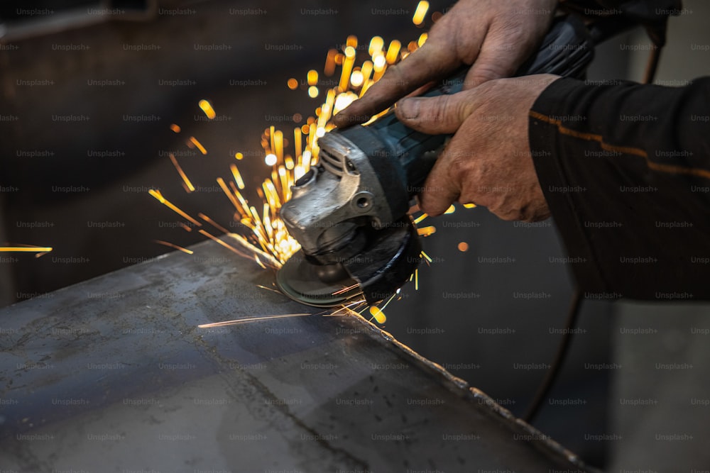 a person using a grinder on a piece of metal