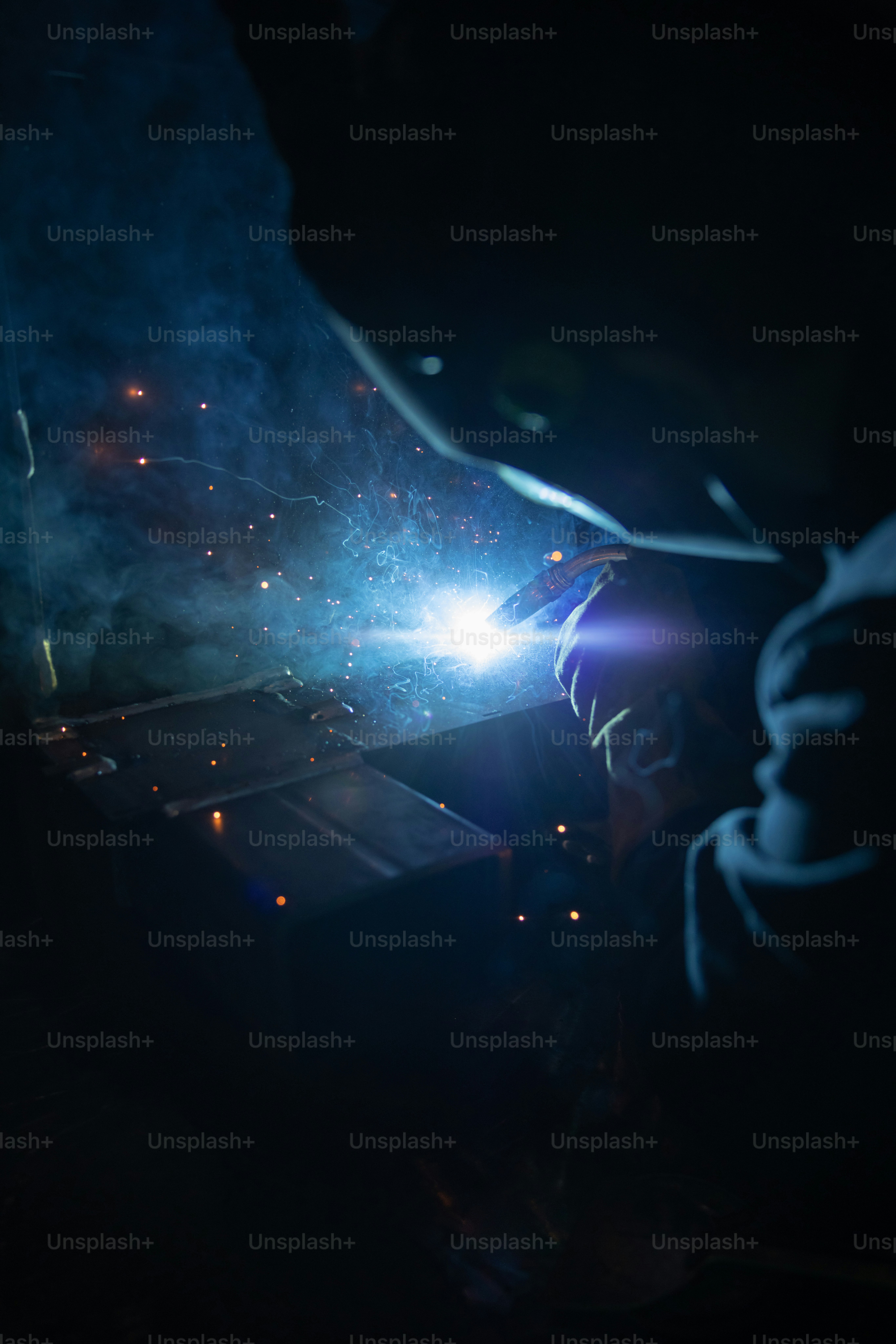 a welder working on a piece of metal in the dark