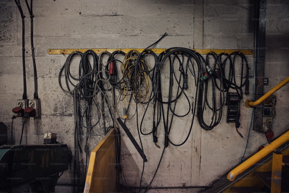 a bunch of wires are hanging on a wall