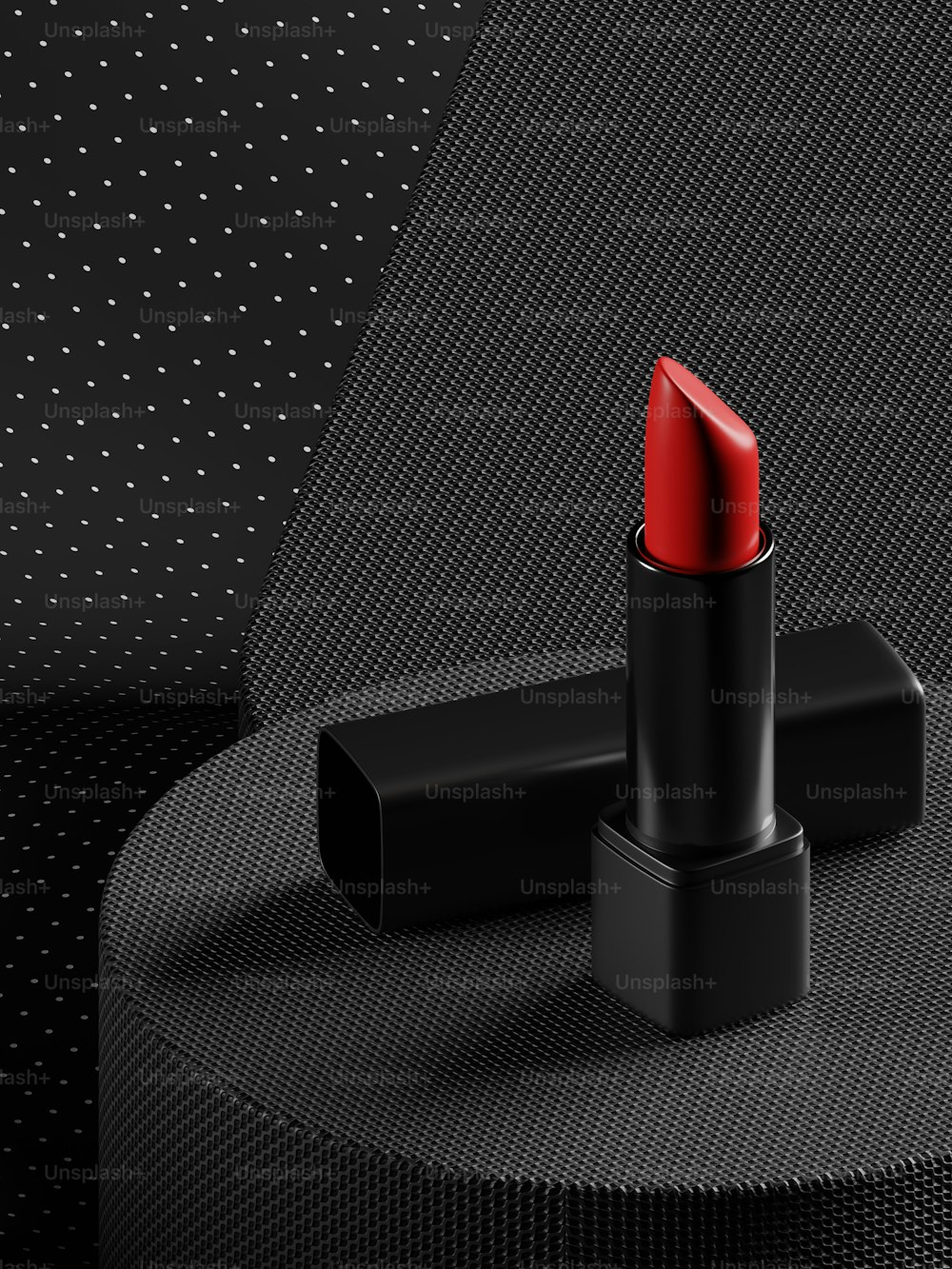 a red lipstick sitting on top of a black table