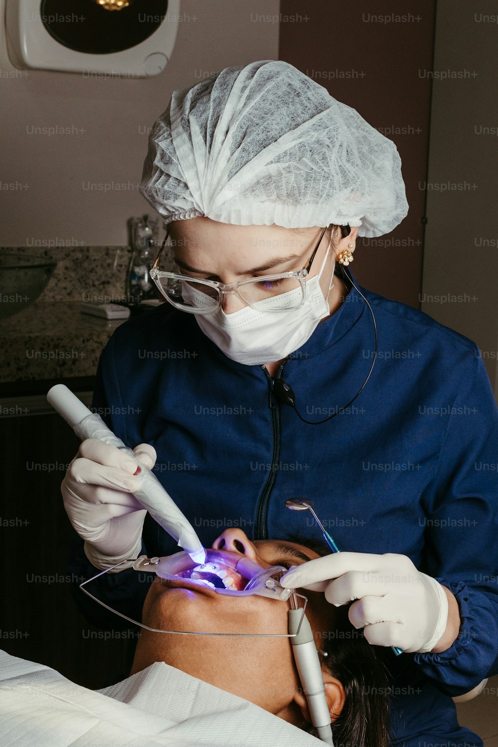 a woman getting her teeth checked by a dentist