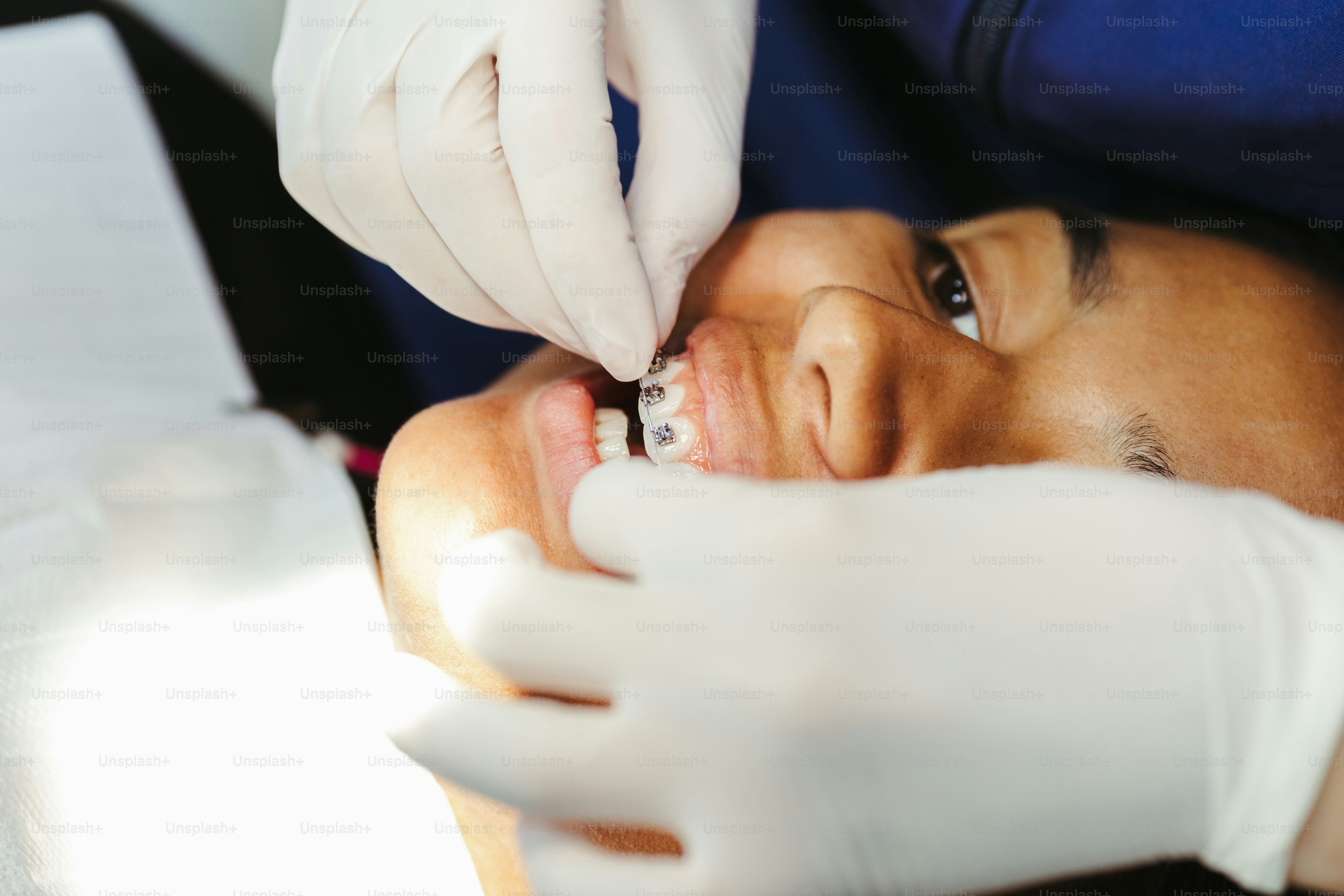 a woman getting her teeth checked by a dentist